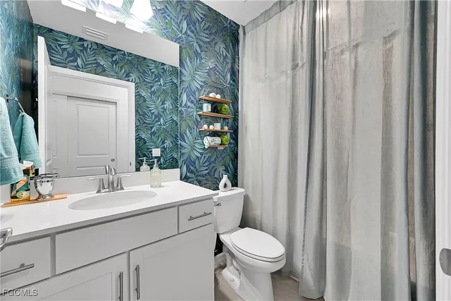 a bathroom with a toilet a sink and a mirror