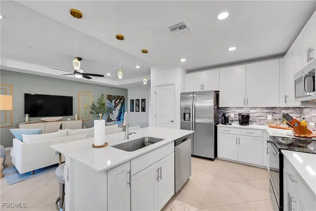 a kitchen that has a sink a stove and a refrigerator