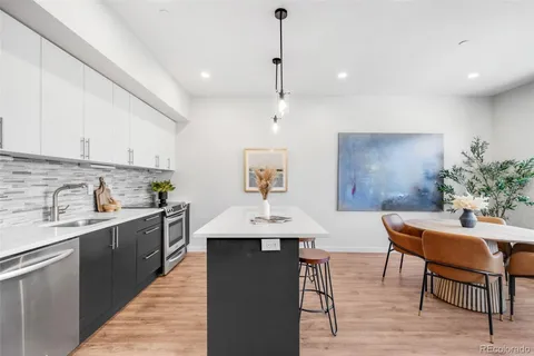 a kitchen with a table chairs sink and cabinets