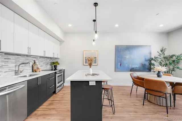 a kitchen with a table chairs sink and cabinets