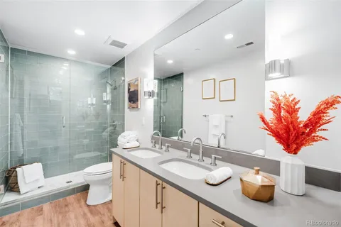 a bathroom with a granite countertop sink mirror vanity and toilet