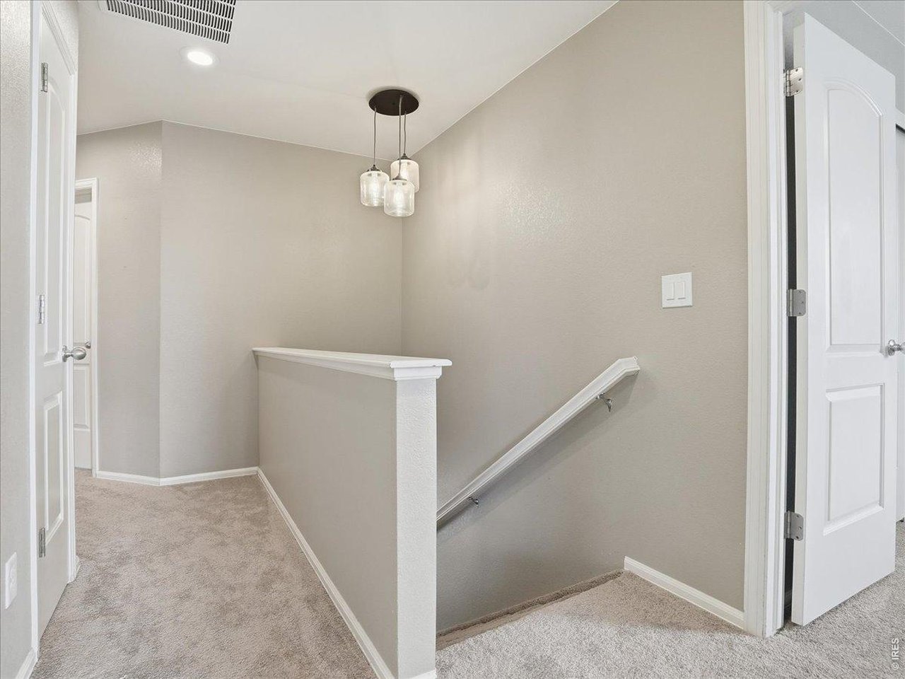 1565 Basildon Court Windsor, CO 80550 - Photo 16 of 36 an empty room with a hallway and a chandelier fan