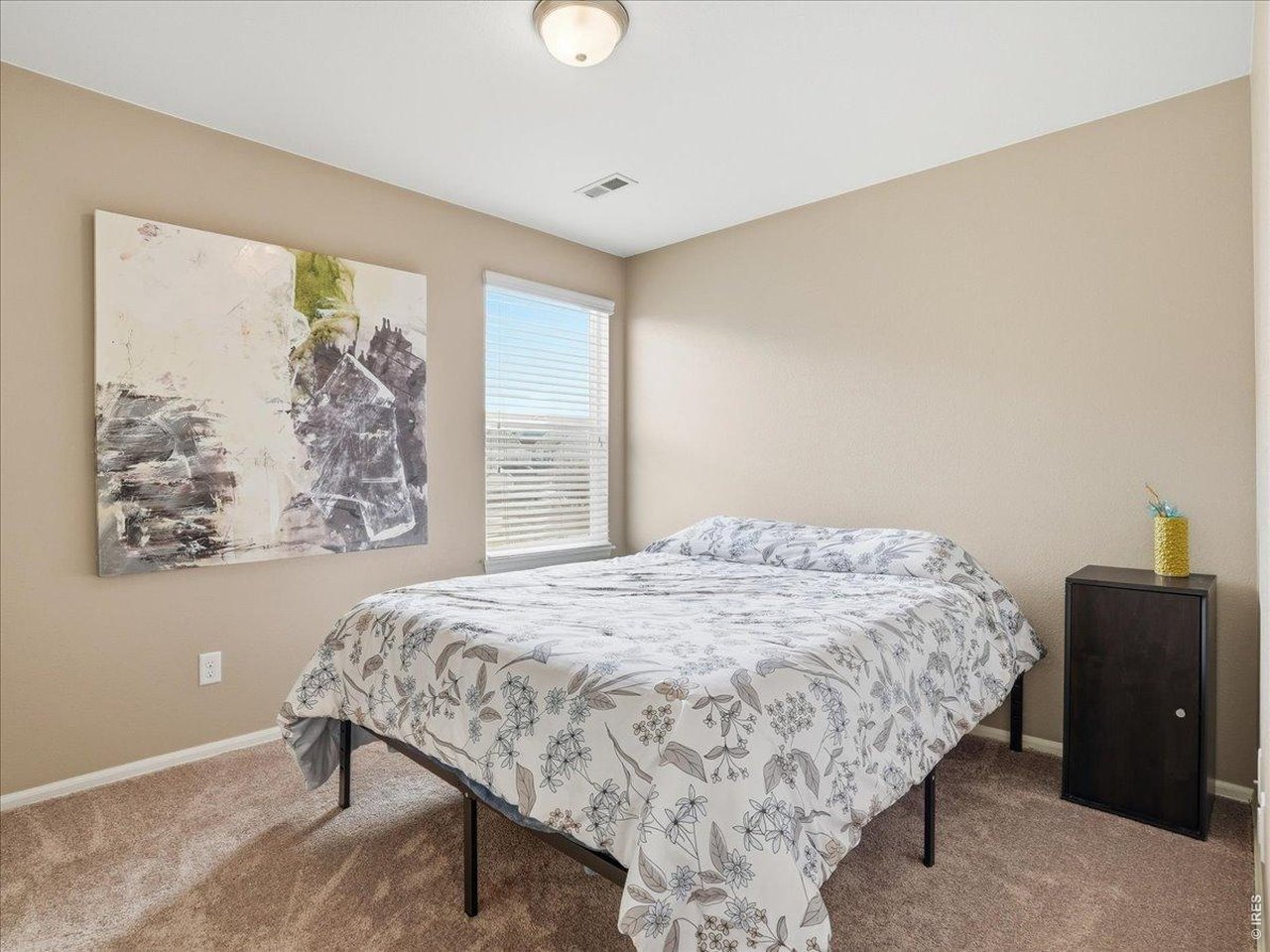 1565 Basildon Court Windsor, CO 80550 - Photo 17 of 36 a bedroom with a bed and a painting on the wall