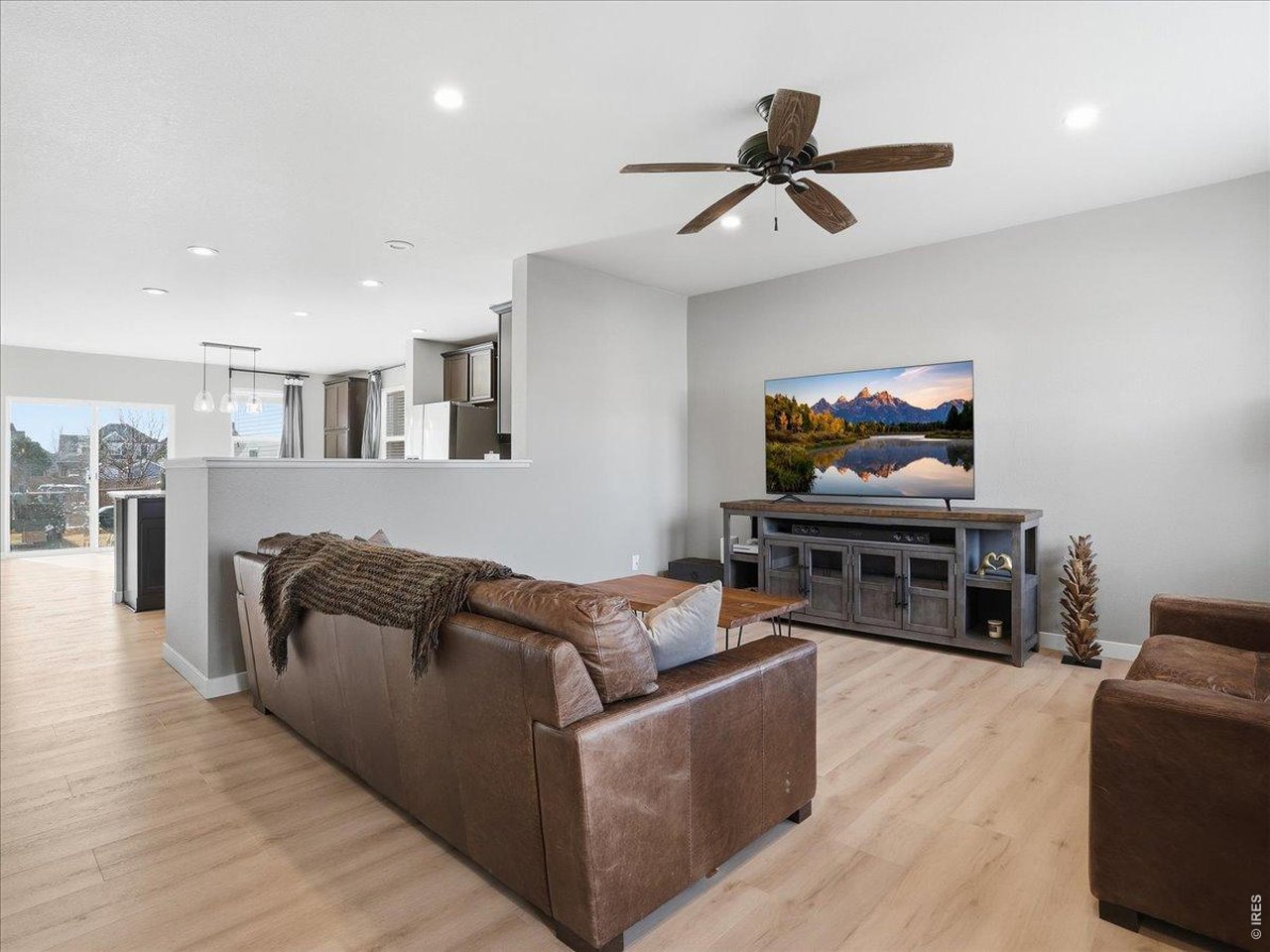 1565 Basildon Court Windsor, CO 80550 - Photo 5 of 36 a living room with furniture and a flat screen tv with wooden floor