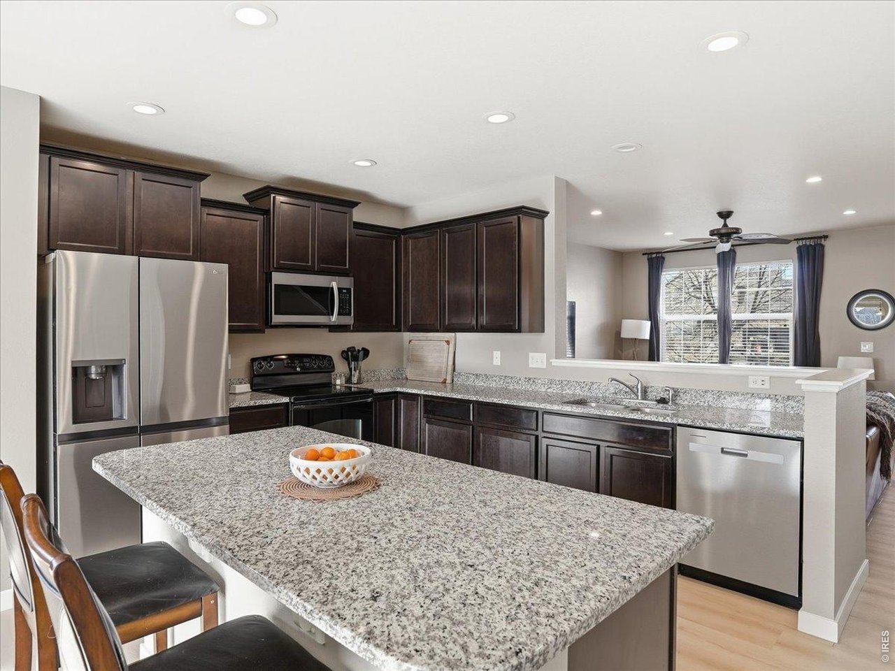 1565 Basildon Court Windsor, CO 80550 - Photo 7 of 36 a kitchen with stainless steel appliances granite countertop a stove refrigerator sink and microwave