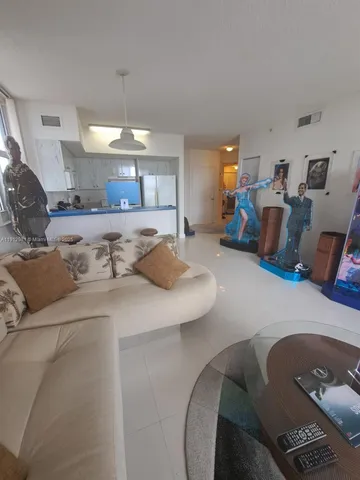 a kitchen with stainless steel appliances kitchen island granite countertop a sink and a refrigerator