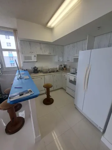 a kitchen with furniture a refrigerator and a sink