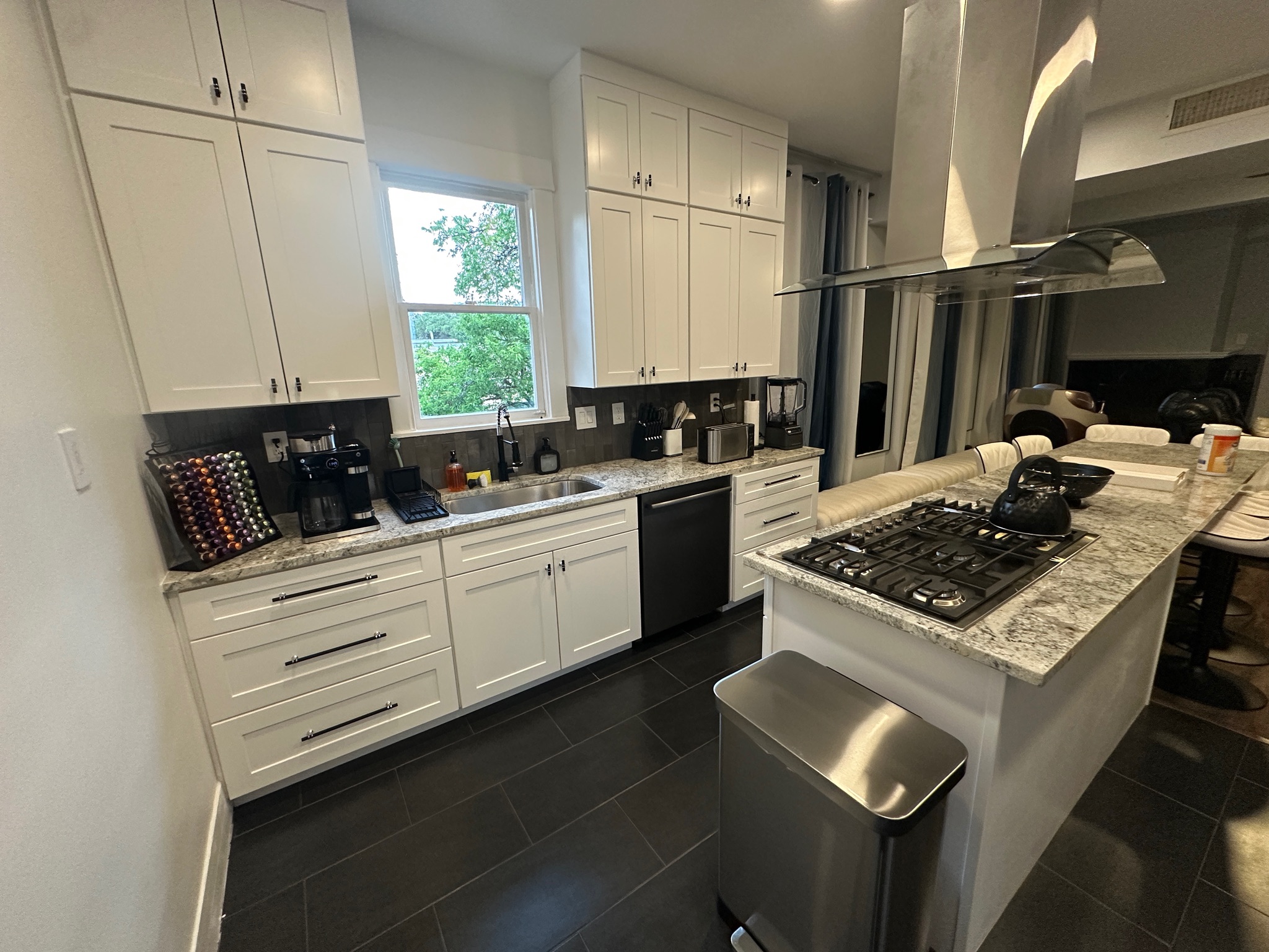 3210 Hampton Road, Unit A B C Austin, TX 78705 - Photo 6 of 42 Kitchen with island exhaust hood, light stone countertops, backsplash, a breakfast bar area, and white cabinets