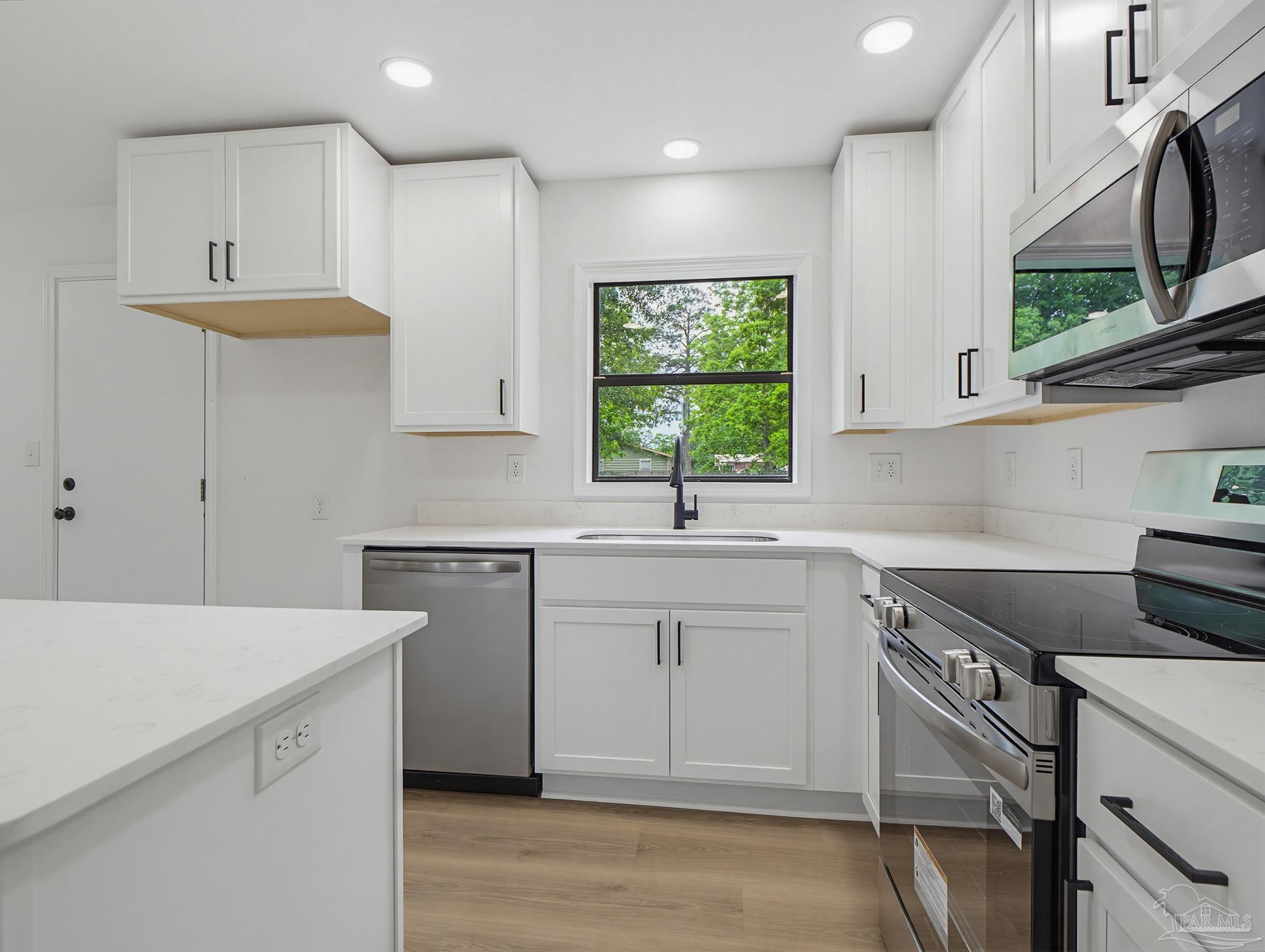 125 Madrid Road Cantonment, FL 32533 - Photo 10 of 16 a kitchen with a sink cabinets and window