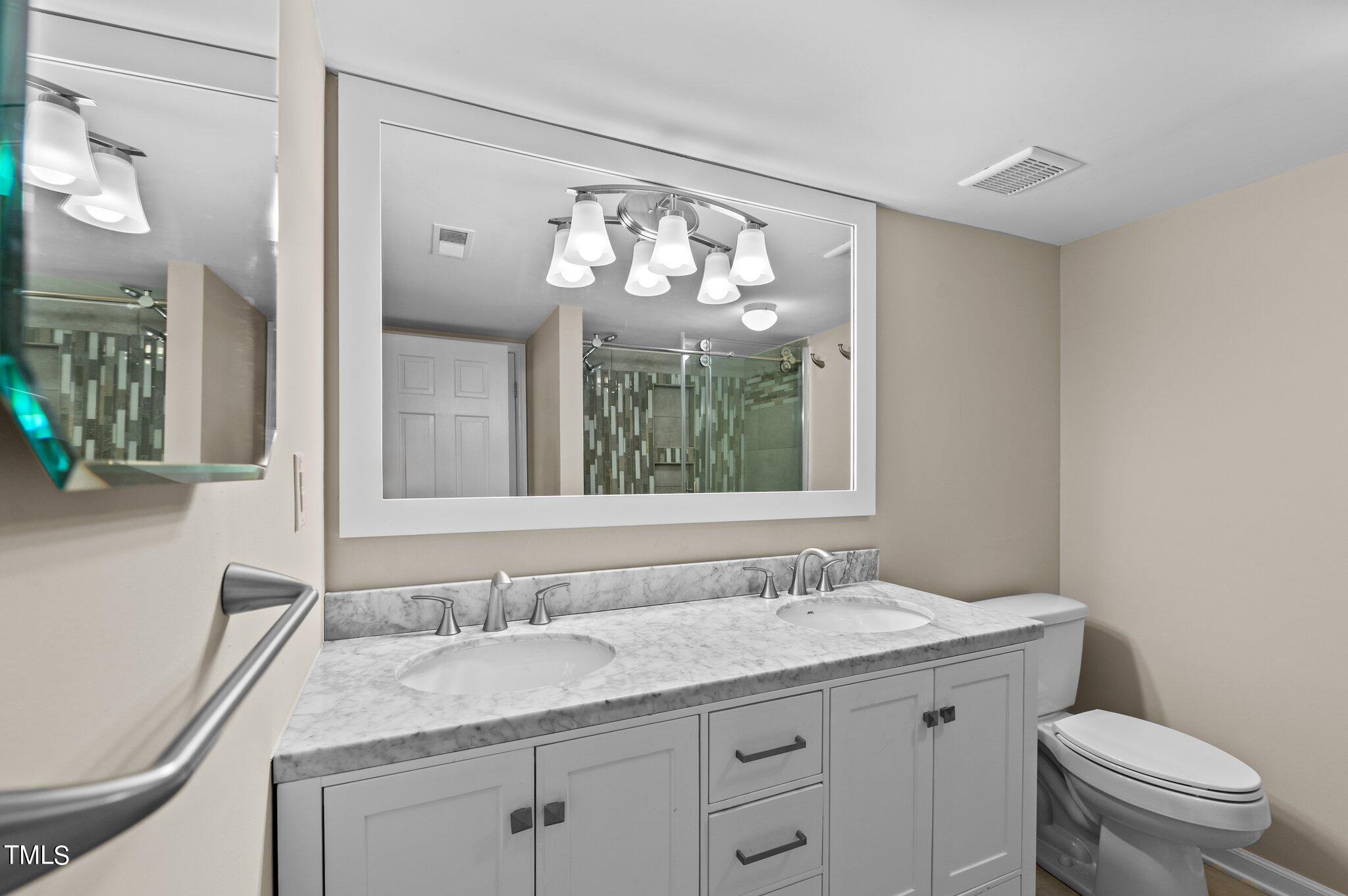1503 Nature Court Raleigh, NC 27609 - Photo 24 of 36 a bathroom with a granite countertop sink a toilet and a mirror