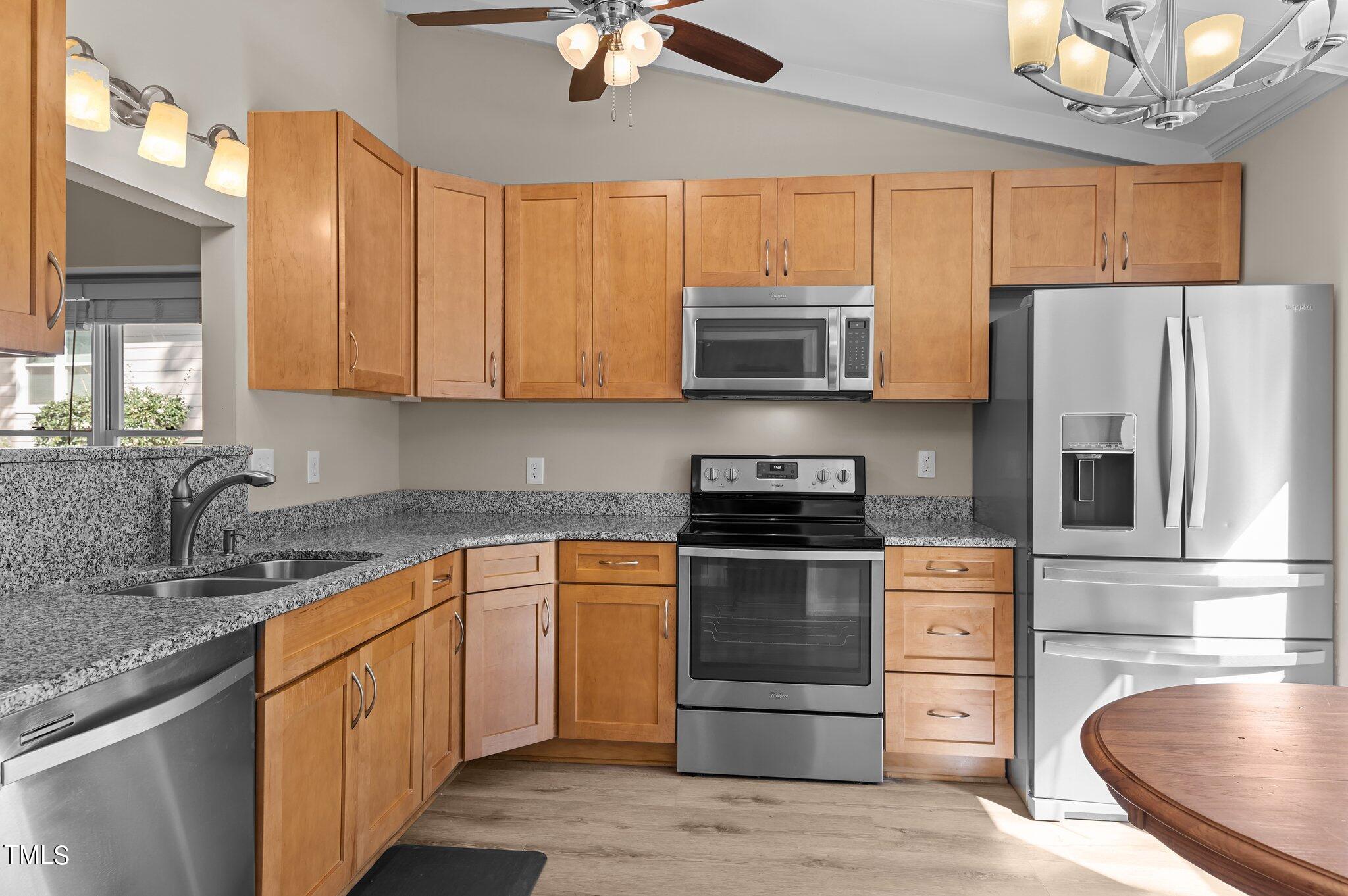 1503 Nature Court Raleigh, NC 27609 - Photo 5 of 36 a kitchen with stainless steel appliances granite countertop a stove top oven a sink dishwasher a refrigerator and a microwave oven with wooden floor