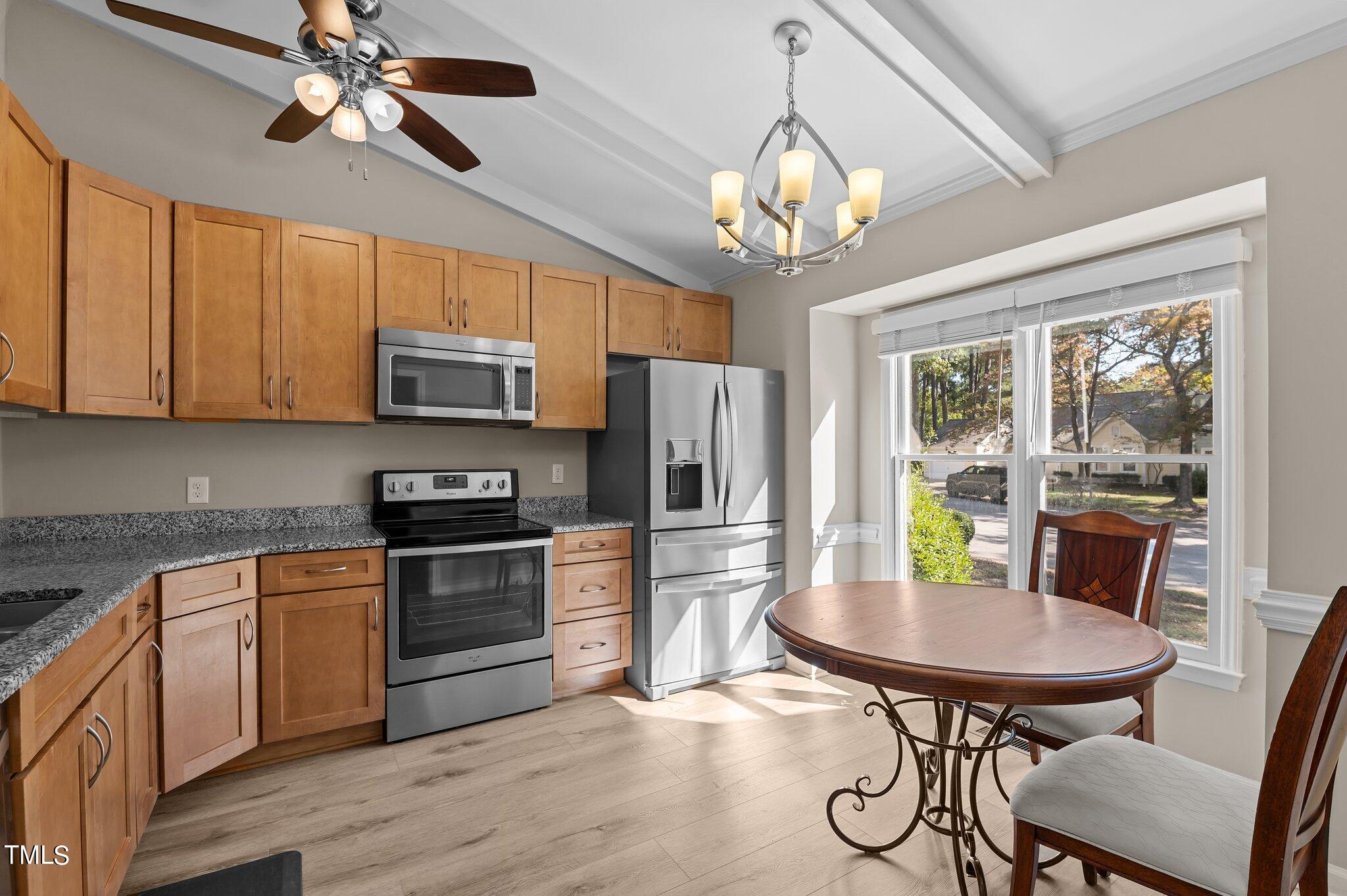 1503 Nature Court Raleigh, NC 27609 - Photo 6 of 36 a kitchen with stainless steel appliances granite countertop a stove top oven a refrigerator a sink dishwasher a dining table and chairs with wooden floor