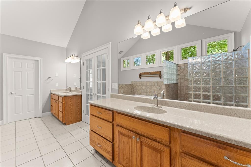 1040 Auburn Road Dacula, GA 30019 - Photo 28 of 42 a bathroom with a double vanity sink a mirror and a bathtub