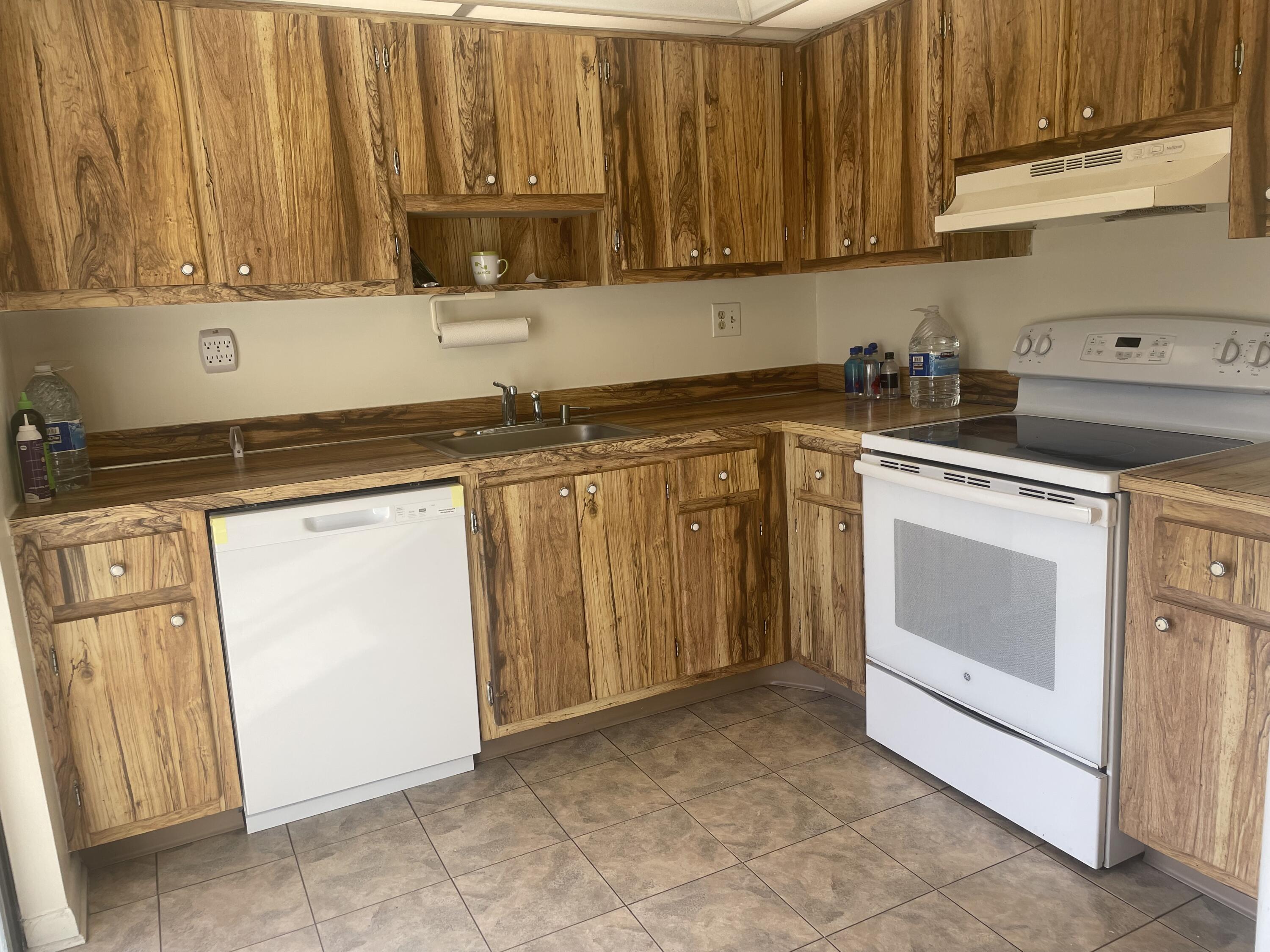 83 Capri B, Unit 83 Delray Beach, FL 33484 - Photo 3 of 26 a kitchen with granite countertop a sink cabinets and stainless steel appliances