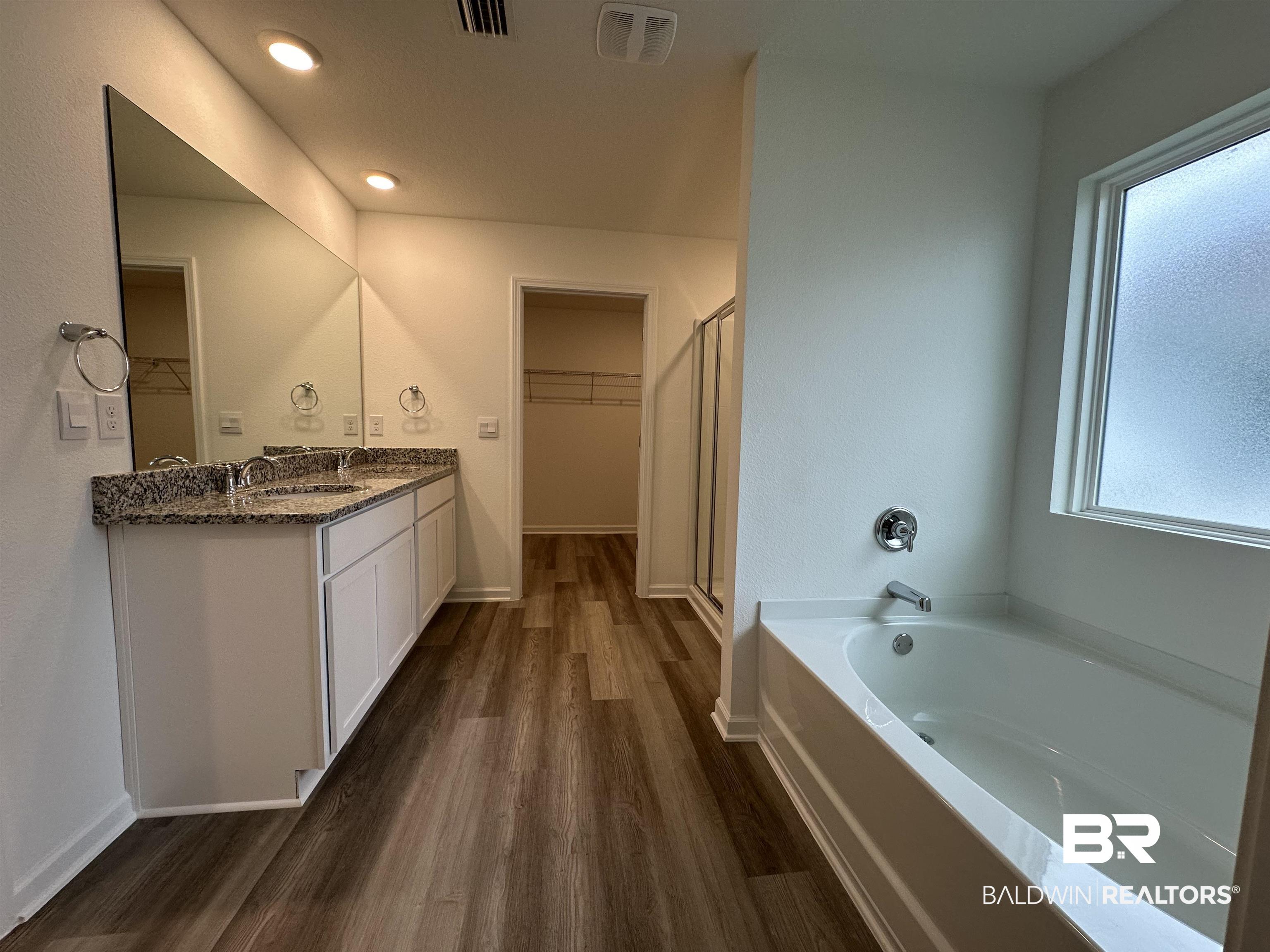 22275 Aleutian Avenue Foley, AL 36535 - Photo 16 of 72 Bathroom with independent shower and bath, vanity, and wood-type flooring