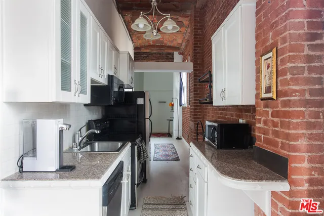 a kitchen with granite countertop a stove and a sink