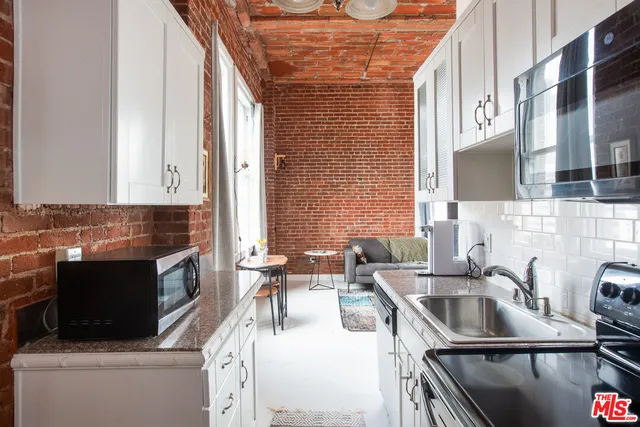 a kitchen with stainless steel appliances a sink a stove and a microwave