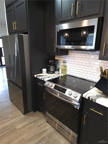 a kitchen with granite countertop a stove and stainless steel appliances