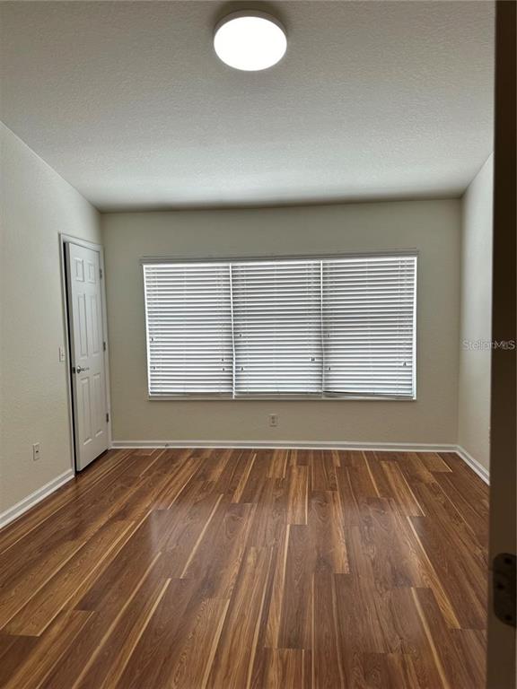4500 Southwest 52nd Circle, Unit 106 Ocala, FL 34474 - Photo 12 of 30 a view of an empty room with wooden floor and a window