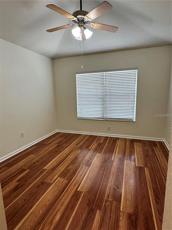 4500 Southwest 52nd Circle, Unit 106 Ocala, FL 34474 - Photo 19 of 30 a view of an empty room with wooden floor and a window