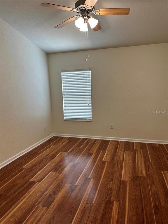 4500 Southwest 52nd Circle, Unit 106 Ocala, FL 34474 - Photo 22 of 30 a view of an empty room with wooden floor and a window