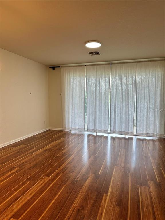4500 Southwest 52nd Circle, Unit 106 Ocala, FL 34474 - Photo 8 of 30 a view of an empty room with wooden floor and a window