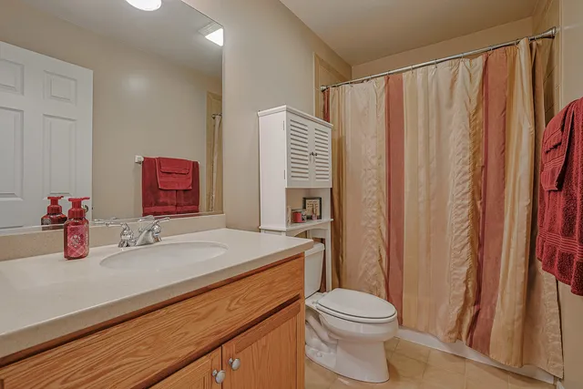 a bathroom with a sink a toilet and shower curtain