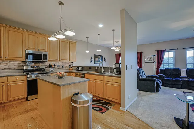 a kitchen with stainless steel appliances granite countertop a sink a stove top oven a counter space and cabinets