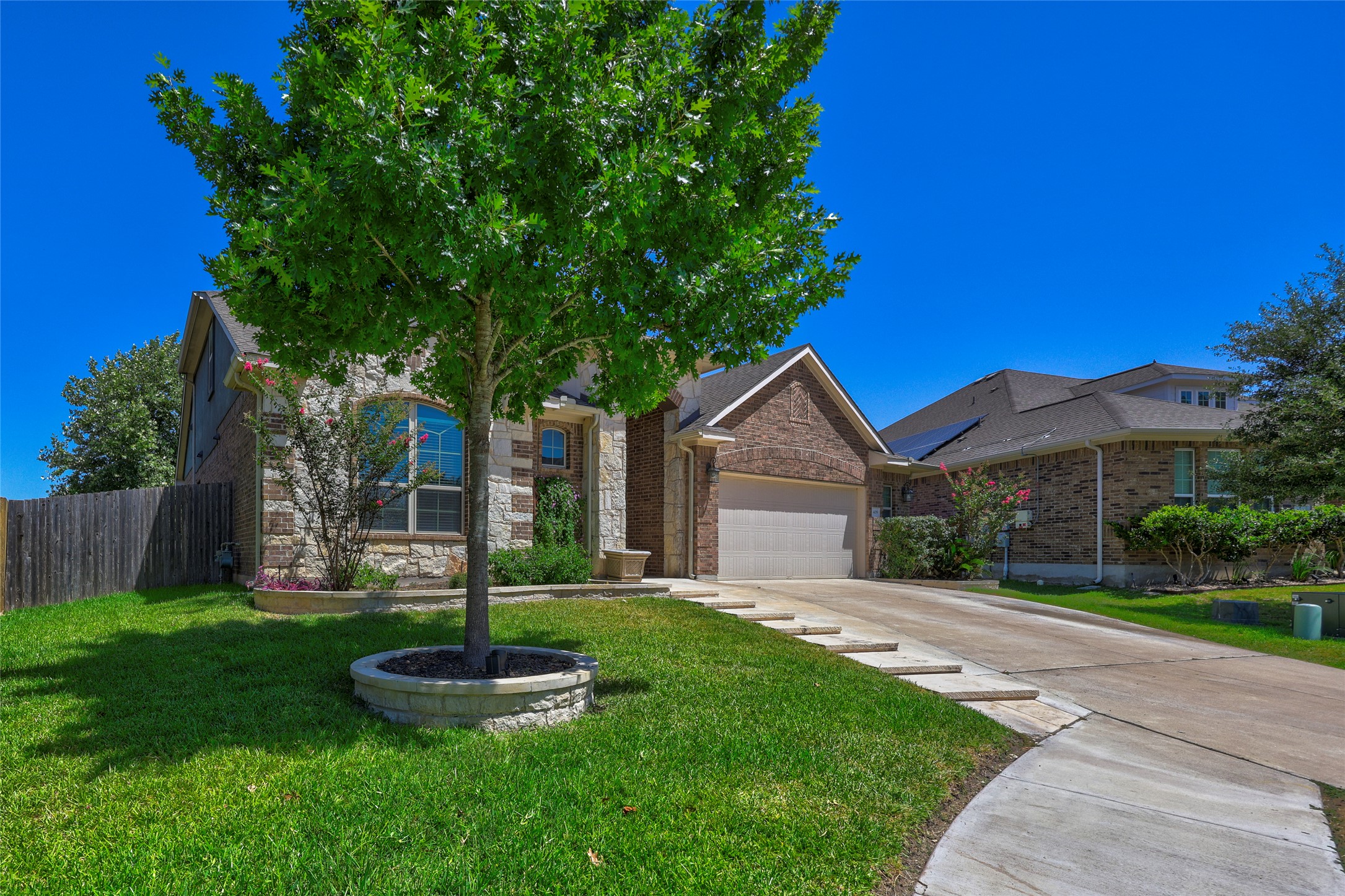 409 Betony Loop Buda, TX 78610 - Photo 3 of 38 A classic brick and stone facade welcomes with lush, well-maintained landscaping and a spacious driveway.