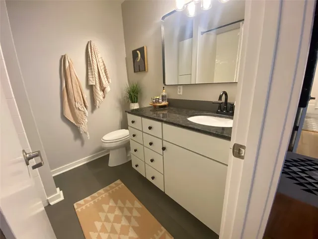 a bathroom with a sink a toilet and a mirror