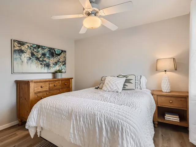 a bedroom with a bed and a painting on the wall