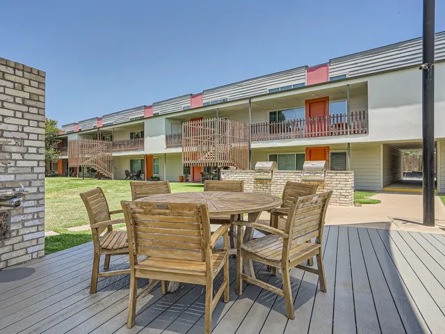 a view of a white house with a big yard and large trees