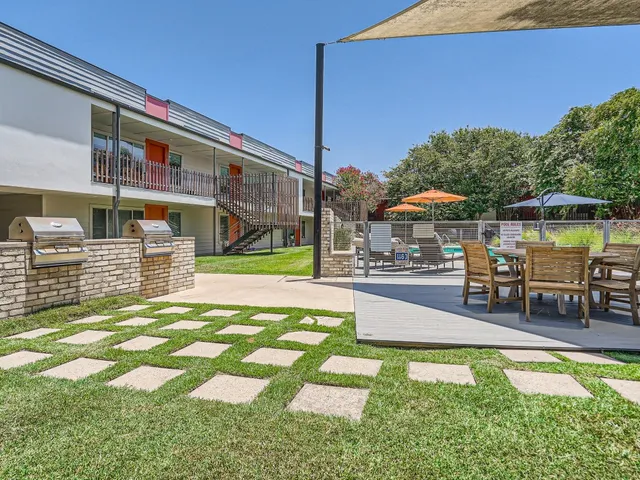a view of a patio with table and chairs with wooden floor and fence