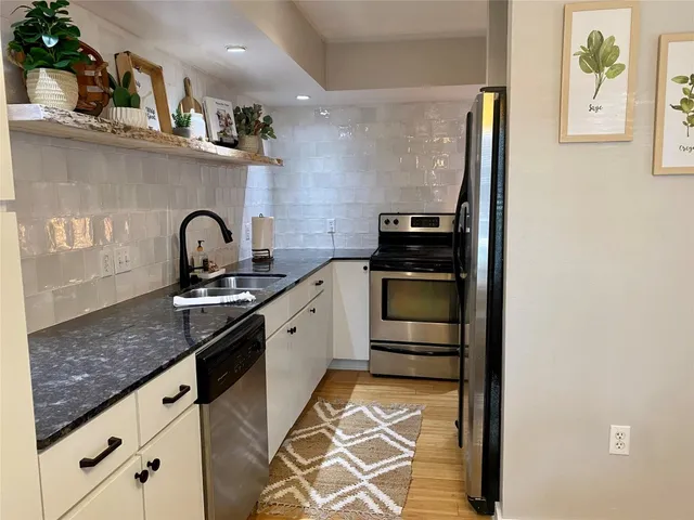 a kitchen with stainless steel appliances granite countertop a sink and cabinets