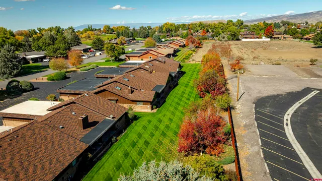 an aerial view of residential houses with outdoor space and parking