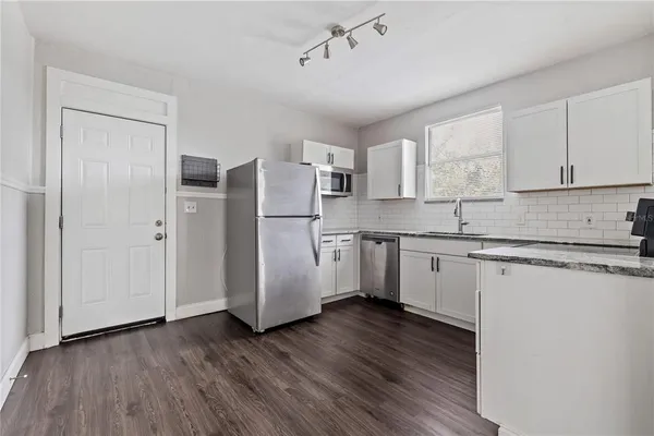 a kitchen with a refrigerator sink and cabinets