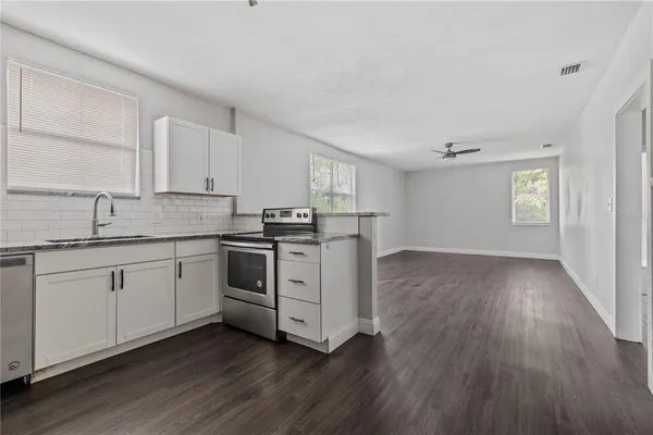 a kitchen with granite countertop white cabinets and white appliances