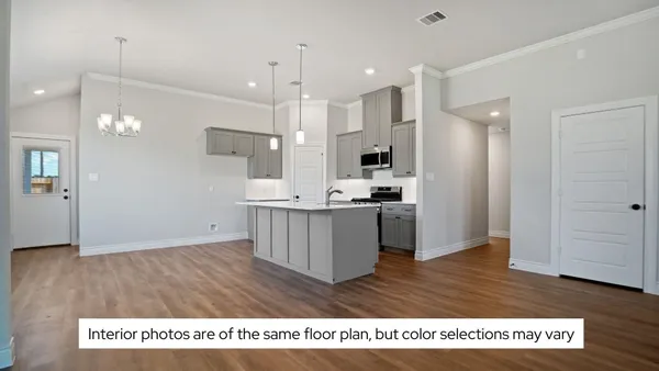 a view of kitchen with kitchen island stainless steel appliances sink cabinets and wooden floor