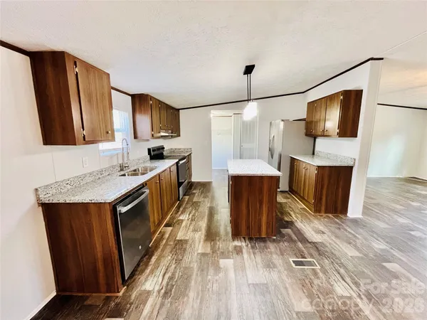 a kitchen with stainless steel appliances granite countertop a sink a stove and a refrigerator