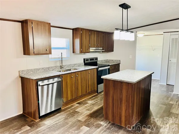 a kitchen with stainless steel appliances granite countertop a sink a stove and a refrigerator