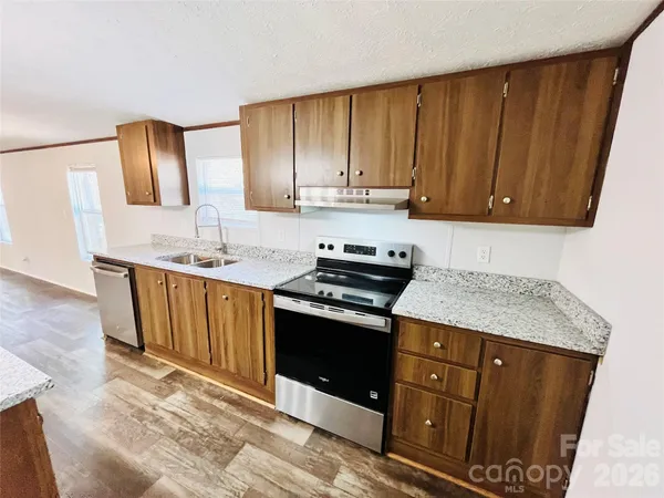 a kitchen with stainless steel appliances granite countertop a sink stove and cabinets