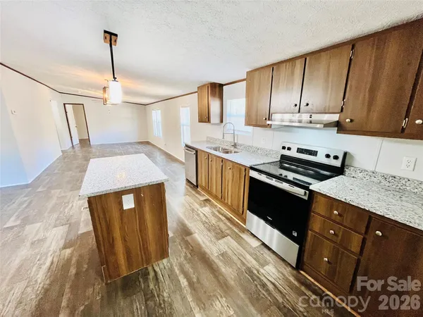 a kitchen with granite countertop a sink a counter space appliances and cabinets