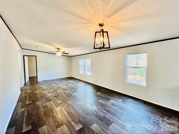 a view of a room with wooden floor and white walls