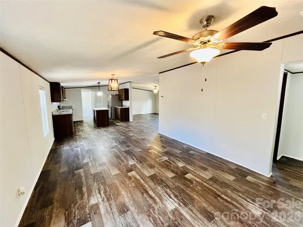 en empty room with wooden floor and fan