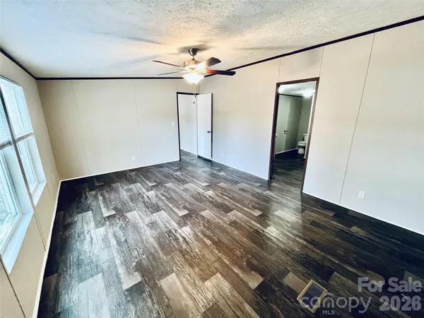 a view of a room with wooden floor staircase and a kitchen space