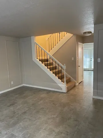 a view of an empty room with cabinet and door