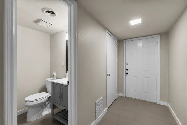 a bathroom with a sink mirror and toilet