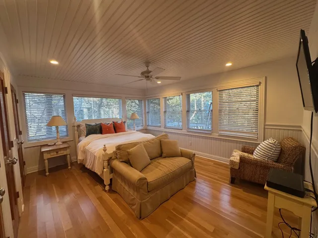 a bedroom with furniture and a large window