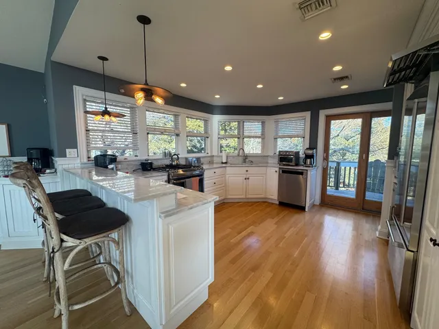 a kitchen with stainless steel appliances granite countertop wooden floors and sink