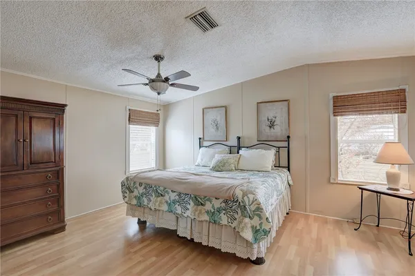 a bedroom with a bed chandelier and a window
